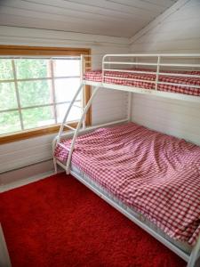 a bedroom with two bunk beds and a window at Sappee Peak Cabin - Bike, Fire, Snow & Adventure in Salmentaka +32 photos