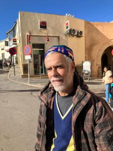 een man met een bandana staat op straat bij Riad Dar Lemdrssa in Fès
