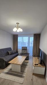 un soggiorno con un divano e un tavolo di Mažeikiai City Apartments a Mažeikiai