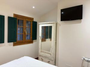 a bedroom with a bed and a tv on a wall at CASINA La RIBERA in Cudillero