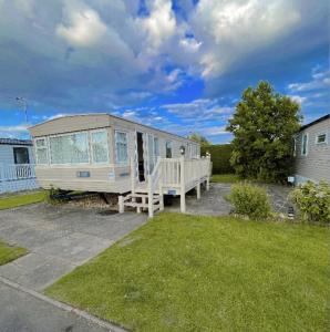 Ein Wohnwagen, der in einem Hof mit Veranda geparkt ist in der Unterkunft Southview Holiday Park in Winthorpe