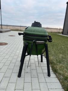 a green suitcase sitting on a stool in the grass at Jūros namai in Palanga