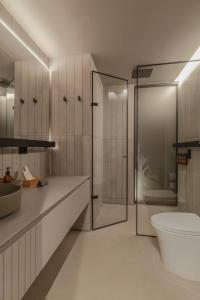 een badkamer met een douche, een toilet en een wastafel bij Wake BioHotel in Medellín