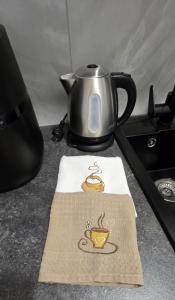 una teiera seduta sopra un fornello di Mažeikiai City Apartments a Mažeikiai