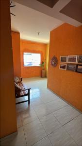 a living room with orange walls and a couch at Pousada e Hostel Santos in Barreirinhas