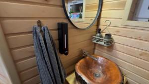 a bathroom with a wooden sink and a mirror at A-frame будиночок in Staraya Guta +36 photos