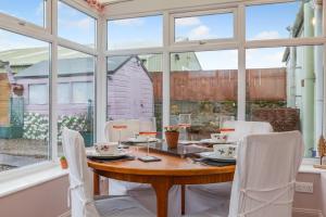 a dining room with a wooden table and white chairs at 2 Bed in Lowick oc-c34008 in Lowick