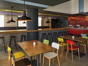 een restaurant met houten tafels en kleurrijke stoelen bij Ibis Culiacan in Culiacán