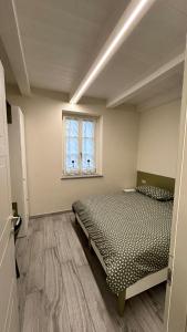 a bedroom with two beds and a window at Baratà Apartments 2 in Savigliano
