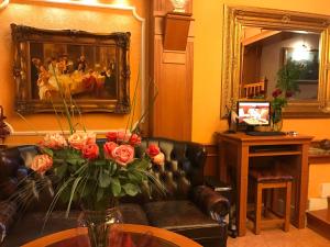 a living room with a couch and a vase of roses at Grand Hotel Residence Pieštany Adult only Boutique hotel Next to Wake Soul Beach in Piešťany