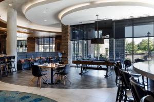 een restaurant met tafels en stoelen en een pooltafel bij Archer Hotel Boston/Burlington in Burlington