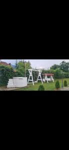 un parco con una panchina bianca e un'altalena di La Casa Bianca a Avrig