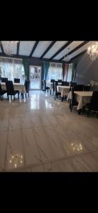 una sala da pranzo con tavoli, sedie e luci di La Casa Bianca a Avrig