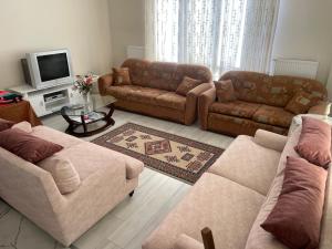 a living room with two couches and a tv at Villa Efes in Hisarcık