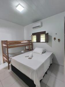 ein weißes Schlafzimmer mit einem Bett und einem Schreibtisch in der Unterkunft Casa de Fagundes PB in Lucena