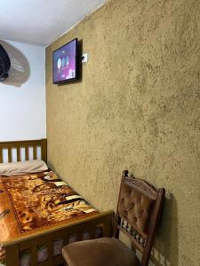 una camera da letto con un letto e una TV a parete di Hospedaje Malvinas ad Alta Gracia Altre 46 foto