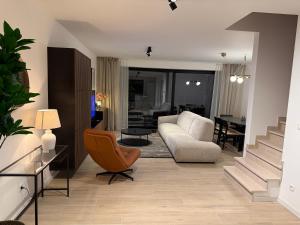 a living room with a couch and a chair at Casa Blanc - Coastal Triplex in Blankenberge