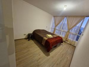 ein Schlafzimmer mit einem Bett und einem großen Fenster in der Unterkunft edificio libertad Iquique con vista y wifi in Iquique