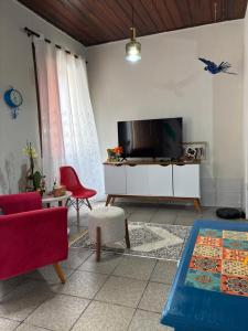 a living room with a flat screen tv on a wall at Quarto em Casa familiar in Belém