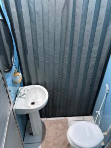 a bathroom with a sink and a toilet at Quarto em Casa familiar in Belém