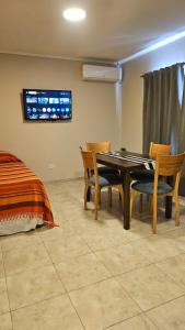 una sala da pranzo con tavolo, sedie e un letto di Edificio-Pellegrini PA a Bragado