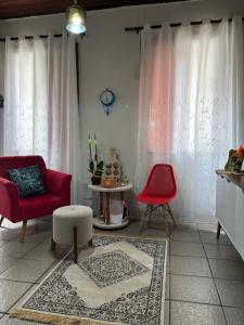 a living room with two red chairs and a rug at Quarto em Casa familiar in Belém