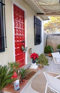 eine rote Tür an einem Haus mit Topfpflanzen in der Unterkunft Silvana campo y ciudad in Córdoba