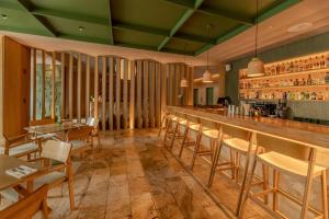 een restaurant met een bar met stoelen en tafels bij The Charlee Hotel in Medellín