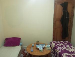 a small room with a table and a bed and a door at Camping Kbir in Moulay Bousselham