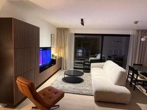 a living room with a white couch and a television at Casa Blanc - Coastal Triplex in Blankenberge +35 photos