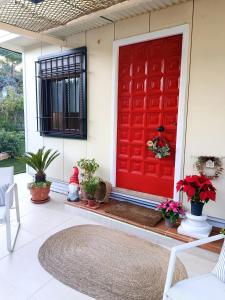 eine rote Tür an einem Haus mit Topfpflanzen in der Unterkunft Silvana campo y ciudad in Córdoba