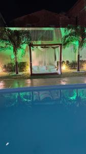 een bed in een kamer met palmbomen 's nachts bij Pousada Linhares in Canoa Quebrada