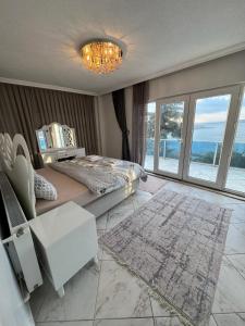 een slaapkamer met een bed en uitzicht op de oceaan bij WHİTE ROSE VİLLA Jakuzili ve Isıtma Havuzlu in Sapanca