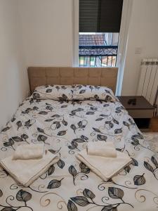 een bed met twee kussens erop bij Royal Queen in Vrnjačka Banja