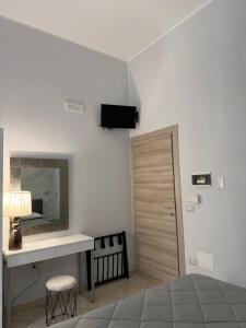 a bedroom with a bed and a desk and a mirror at Dimora Lanamar in Conversano