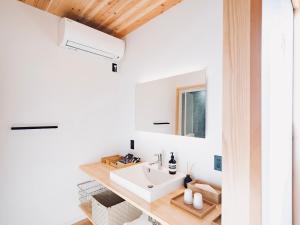 a bathroom with a sink and a mirror at On The Cliff in Karatsu