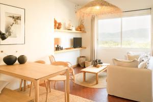 a living room with a table and chairs and a window at Boutique hôtel Château Rouher in Propriano