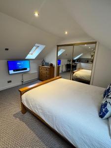 ein Schlafzimmer mit einem großen Bett und einem großen Spiegel in der Unterkunft An Cuiltheann Apartment in Turriff + 4 Fotos