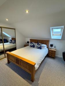 ein Schlafzimmer mit einem Bett und einem großen Spiegel in der Unterkunft An Cuiltheann Apartment in Turriff
