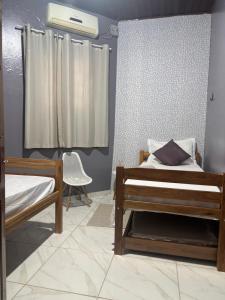 a bedroom with two beds and a window at Quarto em Casa familiar in Belém