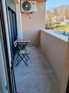 een balkon met 2 stoelen en airconditioning bij Royal Queen in Vrnjačka Banja
