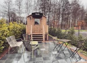 een houten speelhuisje met stoelen en een tafel bij Laurel & Hardy in Mechelen