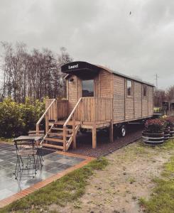 een houten camper met een tafel en stoelen bij Laurel & Hardy in Mechelen