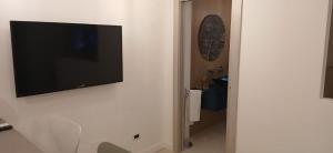 een flatscreen-tv aan een witte muur bij Tao chambre in Taormina