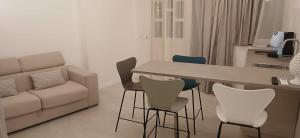 een woonkamer met een bank, een tafel en stoelen bij Tao chambre in Taormina