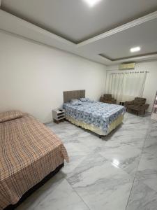 a bedroom with two beds and a large marble floor at The Brown beach House in Rio Grande