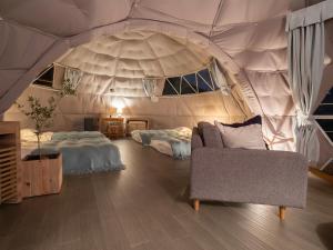 a room with two beds and a couch in a tent at On The Cliff in Karatsu