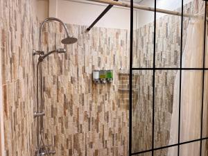 a bathroom with a shower with a glass door at Faaora Lodge, little paradise Moorea in Haapiti