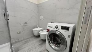a bathroom with a washing machine and a toilet at Baratà Apartments 2 in Savigliano