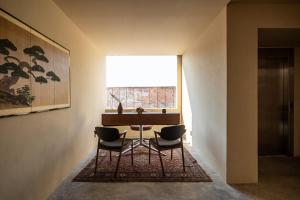 a table and chairs in a room with a window at Hotel Oculto in Mexico City